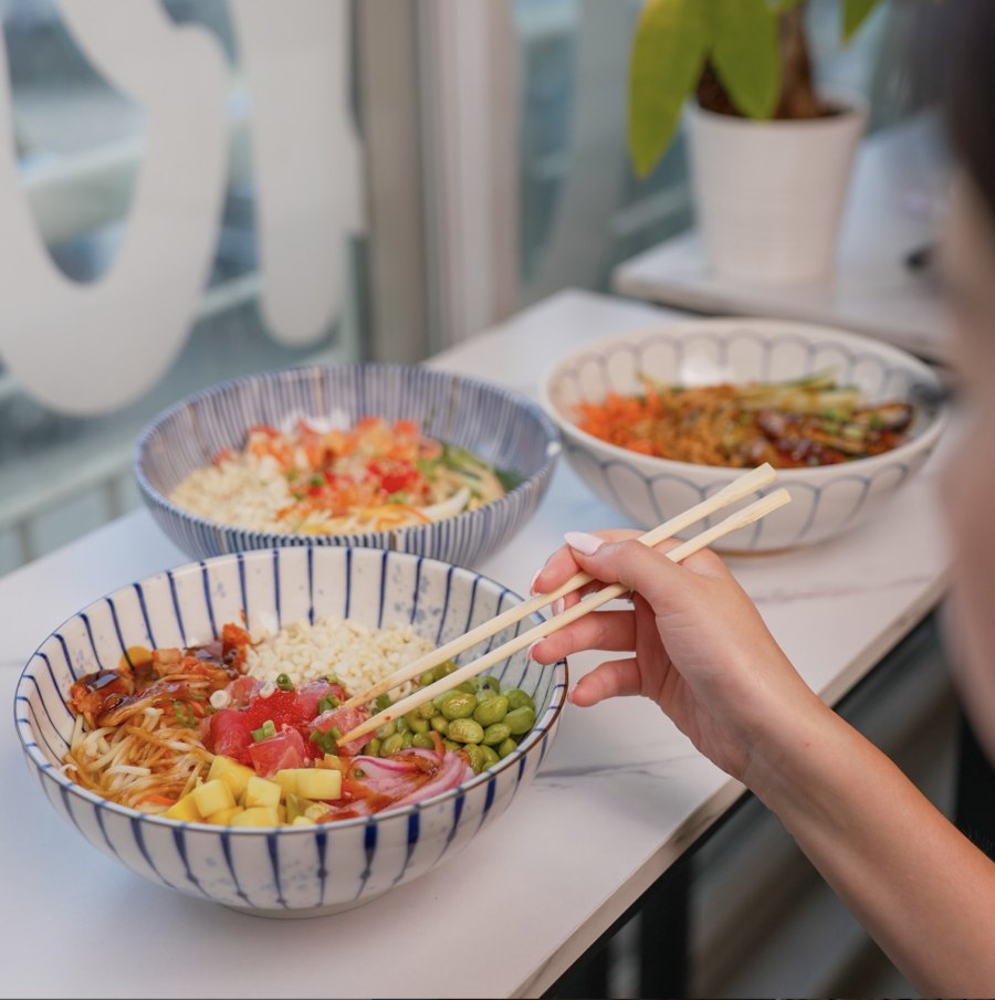 Chef preparing poke bowl in open kitchen counter at Montreal restaurant