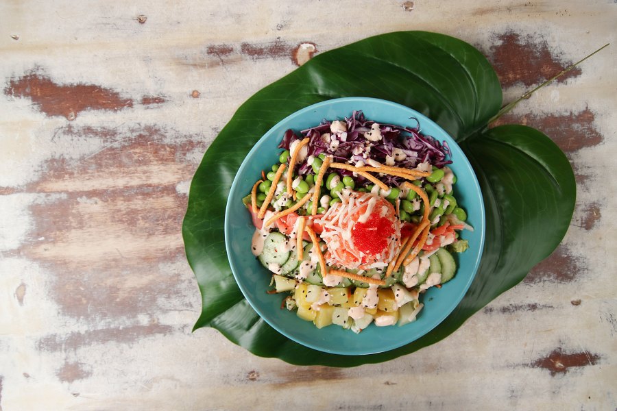Chef preparing poke bowl in open kitchen counter at Montreal restaurant
